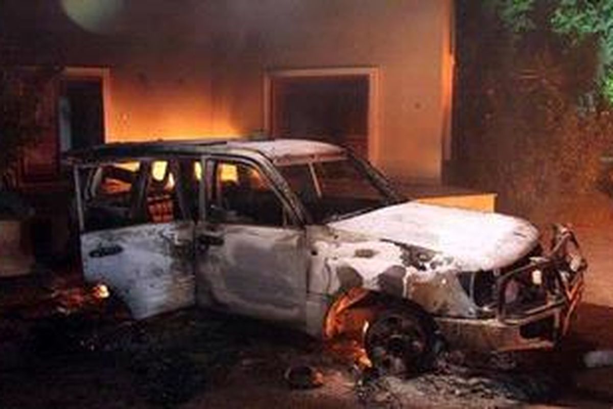 Sebuah mobil hangus dibakar massa yang melakukan unjuk rasa di kantor Konsulat AS di Benghazi, Libya, Rabu (12/9/2012).