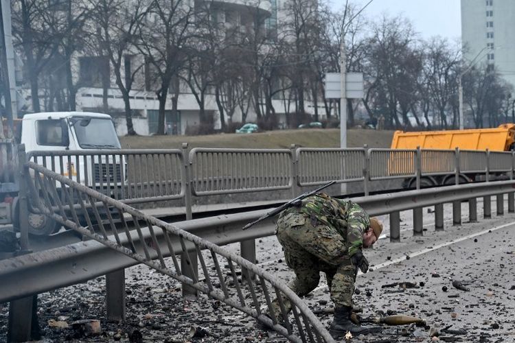 Tentara Ukraina memungut amunisi yang belum meledak setelah pertempuran melawan Rusia di ibu kota Kiev, Sabtu (26/2/2022) pagi.