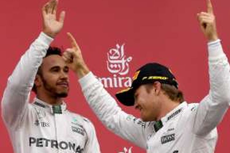 Pebalap Mercedes asal Jerman, Nico Rosberg (kanan), dan rekan satu timnya asal Inggris, Lewis Hamilton, merayakan hasil finis pertama dan ketiga pada balapan GP Jepang di asa podium Sirkuit Suzuka, Minggu (9/10/2016).