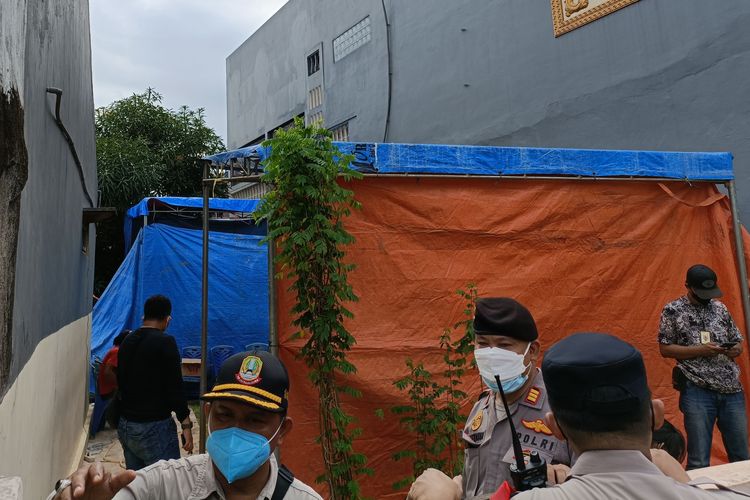 Polisi menjaga tenda di dekat makam korban AY yang berada di Jalan Setia 1E Jatiwaringin, Gang Garuda, Pondok Gede, Kota Bekasi, Selasa (25/1/2022). Di dalam tenda tersebut terdapat petugas kedokteran forensik sedang melakukan otopsi terhadap jenazah AY.