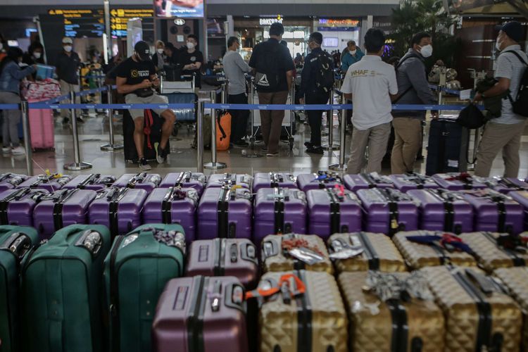 Para calon penumpang pesawat internasional mengantre di loket lapor diri di Terminal 3 Bandara Internasional Soekarno Hatta, Tangerang, Banten, Selasa (1/3/2022).