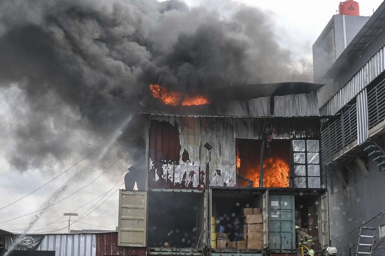 Petugas Dinas Penanggulangan Kebakaran dan Penyelamatan (Gulkarmat) DKI berusaha memadamkan api yang membakar gudang kabel fiber optik di kawasan Plumpang Semper Raya, Jakarta Utara, Senin (23/1/2023). Menurut petugas, sebanyak 12 unit mobil pemadam kebakaran dikerahkan untuk memadamkan api yang membakar gudang penyimpanan kabel fiber optik yang diduga akibat korsleting listrik.