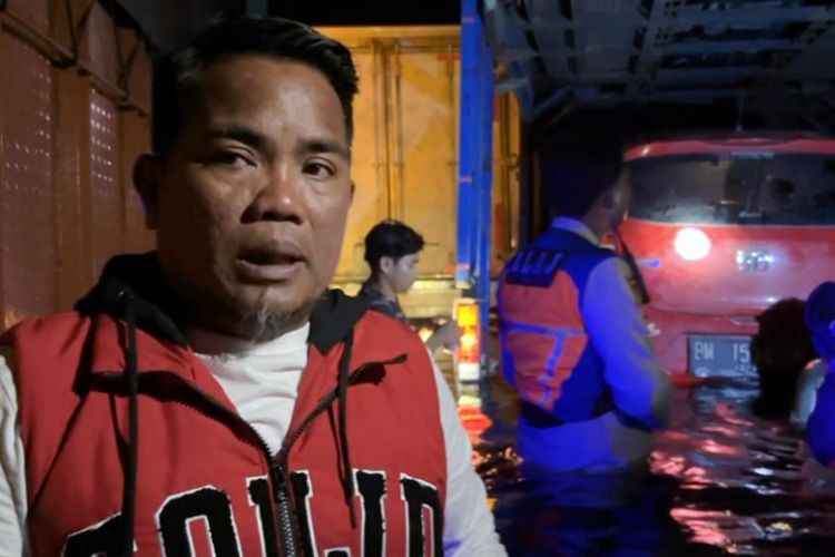Bupati Pelalawan Zukri Misran saat ikut mengarungi banjir untuk mengevakuasi kendaraan mogok di jalan lintas timur, di Kabupaten Pelalawan, Riau, Jumat (12/1/2024) dini hari.