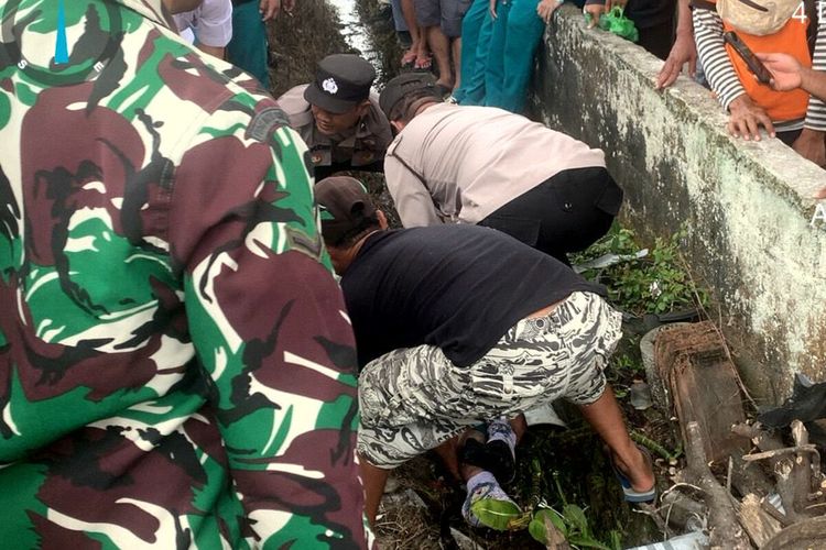 Warga dan petugas kepolisian mengangkat salah satu dari dua pelajar MAN 2 Blitar yang tewas tertabrak kereta api di perlintasan kereta tanpa palang pintu di Kelurahan Tangkil, Kecamatan Wlingi, Kabupaten Blitar, Senin (4/12/2023)