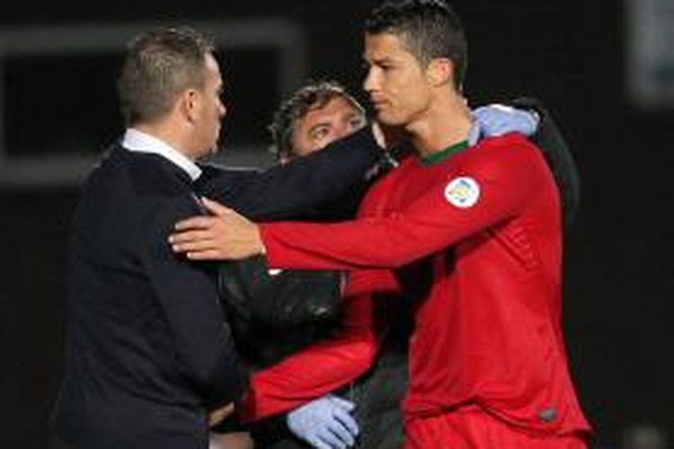 Gelandang Portugal, Cristiano Ronaldo (kanan), mendapat sambutan dari manajer timnas Paulo Bento, ketika dia ditarik keluar dalam laga kualifikasi Grup F Piala Dunia 2014 melawan Irlandia Utara, Jumat (6/9/2013). Dalam laga itu Ronaldo cetak tiga gol untuk membawa Portugal menang 4-2.