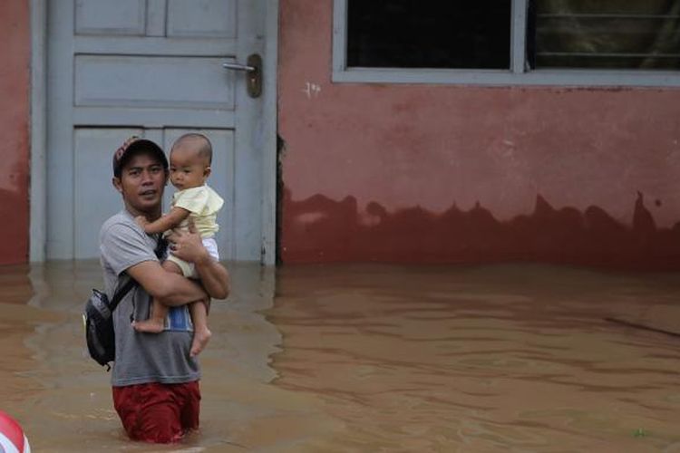 Warga berjalan menembus banjir di Kelurahan Cipinang Melayu, Kecamatan Makasar, Jakarta Timur, Senin (20/2/2017). Banjir kerap terjadi menyusul meluapnya Kali Sunter yang melintasi Cipinang Melayu, ditambah, curah hujan yang tinggi sepanjang hari kemarin.