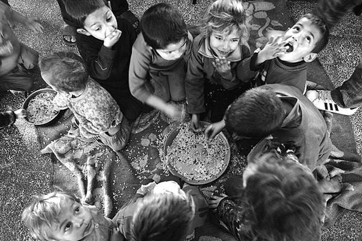 Anak-anak pengungsi Palestina, Senin (12/1), makan seadanya di sekolah PBB di kamp pengungsi Jebaliya, Jalur Gaza utara.