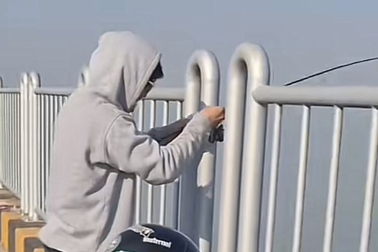 Tangkapan layar video yang memperlihatkan pria memancing di Jembatan Suramadu