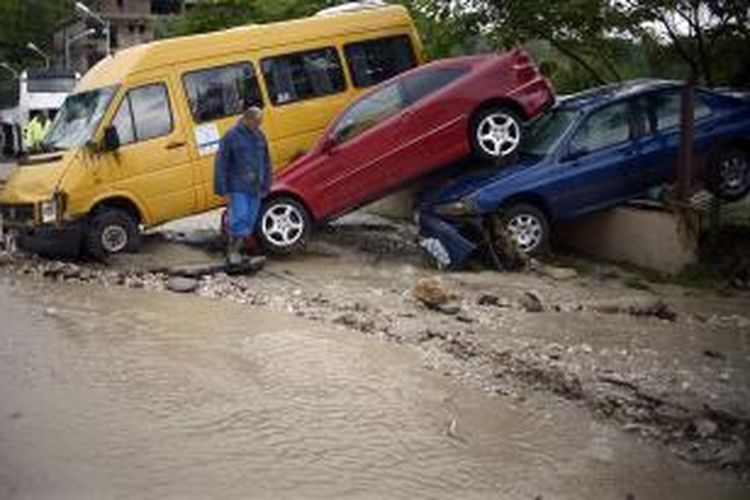 Seorang pria melintas di jalanan yang baru saja berubah menjadi jalur air dari banjir bandang di Varna, Bulgaria, Jumat (20/6/2014). Banjir bandang ini menewaskan setidaknya 14 orang setelah hujan deras mengguyur kawasan ini pada Kamis (19/6/2014) malam.