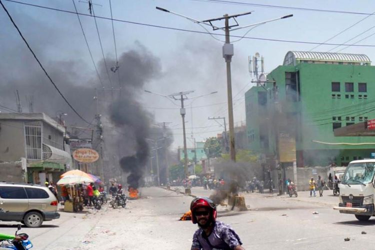 Warga Haiti yang memprotes harga tinggi dan kekurangan bahan bakar membakar ban di jalan Port-au-Prince pada 13 Juli 2022.