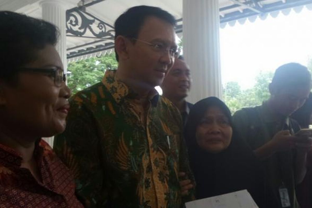 Gubernur DKI Jakarta Basuki Tjahaja Purnama bersama Tin Suwito (kerudung hitam), warga yang mengadu soal tunggakan BPJS di Balai Kota DKI Jakarta, Jalan Medan Merdeka Selatan, Selasa (28/2/2017). 