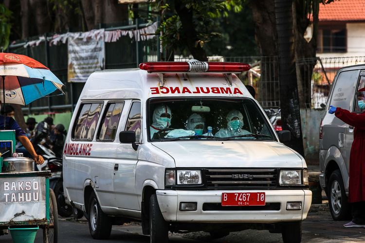 Petugas kesehatan menggunakan alat pelindung berada di mobil ambulans menuju Rumah Sakit Darurat Wisma Atlet untuk mengantar pasien positif Covid-19 orang tanpa gejala (OTG) di Puskesmas Kecamatan Tebet, Jakarta Selatan, Kamis (17/9/2020). Pemerintah Provinsi DKI Jakarta mengetatkan kembali pembatasan sosial berskala besar, per senin 14 september. Pasien positif Covid-19 tanpa gejala (orang tanpa gejala/OTG) yang sebelumnya bisa menjalani isolasi mandiri di rumah, saat ini harus dikarantina di tempat isolasi pemerintah, seperti di Rumah Sakit Darurat Wisma Atlet.