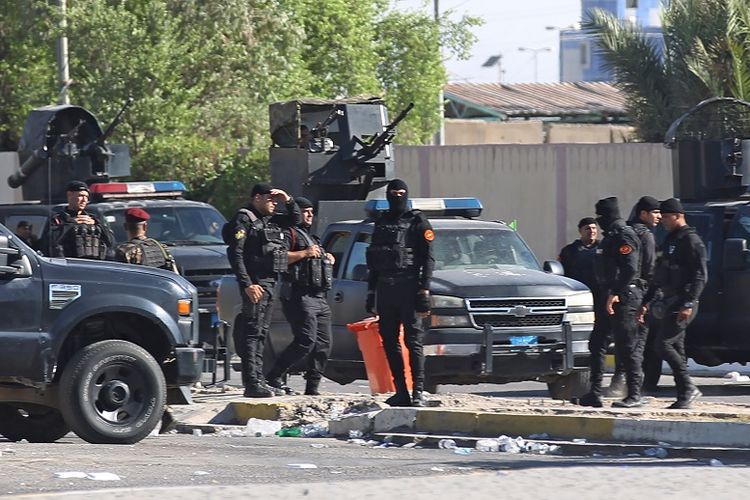 Pasukan keamanan Irak berjaga di luar kantor kementerian dalam negeri selama aksi demonstrasi di Lapangan Khellani, Baghdad, pada Jumat (4/10/2019) pekan lalu.