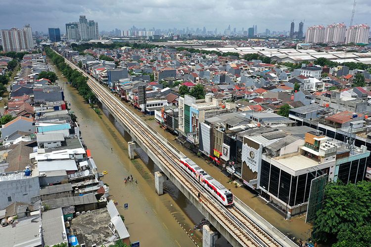 Kereta LRT melintas saat banjir merendam Jalan Boulevard Raya, Kelapa Gading, Jakarta Utara, Minggu (23/2/2020). Hujan deras sejak Minggu, 23 Februari dini hari membuat sejumlah daerah di Ibu Kota tergenang banjir.