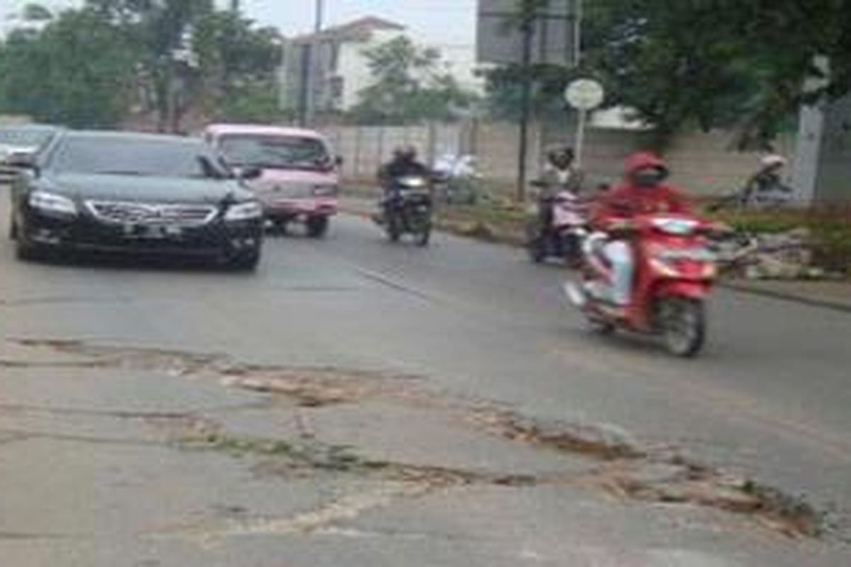 Jalan rusak di depan perumahan Taman Palem Jakarta Barat pada Selasa (11/12/2012). Jalan ini merupakan jalan utama menuju bandara dari arah Cengkareng.
