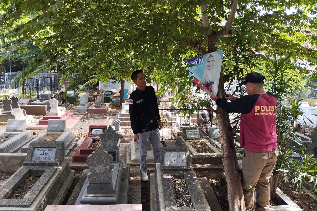 Komisioner Bawaslu Kota Cirebon Nurul Fajri bersama Satpol PP menertibkan APK yang dipasang di area kuburan atau TPU Kemlaten Kecamatan Harjamukti Kota Cirebon, Rabu (24/1/2024)