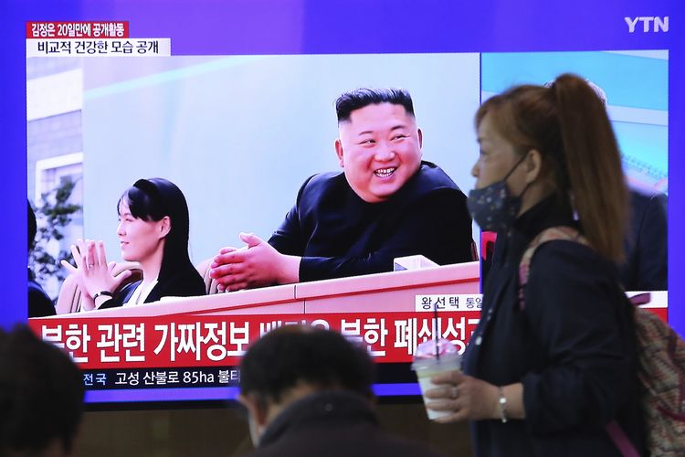 Seorang perempuan melintas di depan layar televisi Stasiun Kereta Api Seoul, Korea Selatan, yang menampilkan kemunculan kembali Pemimpin Tertinggi Korea Utara Kim Jong Un, dalam sebuah program berita, Sabtu (2/5/2020). Kim Jong Un muncul lagi di hadapan publik usai menghilang selama 20 hari, untuk menghadiri peresmian pabrik pupuk di Provinsi Pyongan Selatan, dekat ibu kota Pyongyang.