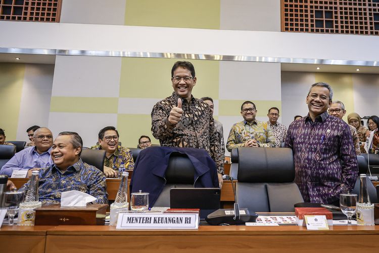Menteri Keuangan Purbaya Yudhi Sadewa (tengah) bersama Wakil Menteri Keuangan Suahasil Nazara (kanan) dan Gubernur Bank Indonesia (BI) Perry Warjiyo (kiri) bersiap mengikuti rapat kerja dengan Badan Anggaran (Banggar) DPR di Kompleks Parlemen, Senayan, Jakarta, Kamis (18/9/2025). Banggar DPR dan pemerintah menyetujui belanja negara direvisi menjadi Rp3.842,7 triliun dalam RAPBN 2026, atau selisih Rp56,2 triliun dari rancangan sebelumnya Rp3.786,5 triliun. 
