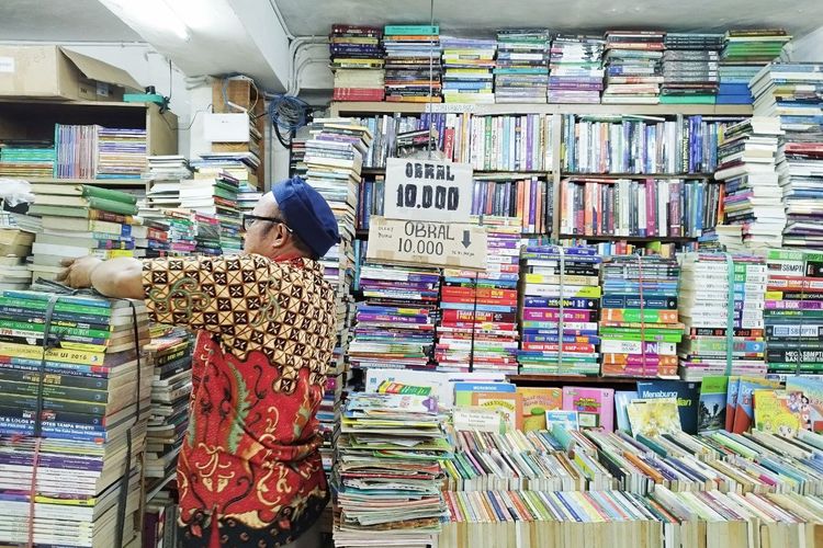 Subhil Khair Tobing (53), seorang pedagang buku di Kwitang, Jakarta Pusat, yang mengobral bukunya seharga 10 ribuan. (KOMPAS.com/Xena Olivia)