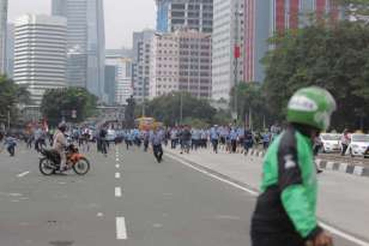 Sejumlah pengemudi ojek online terlibat aksi saling lempar batu dengan para sopir taksi yang berdemonstrasi di Jalan Sudirman, Jakarta, Selasa (22/3/2016). Aksi ini dipicu karena salah satu pengemudi ojek online disweeping oleh para demonstran.