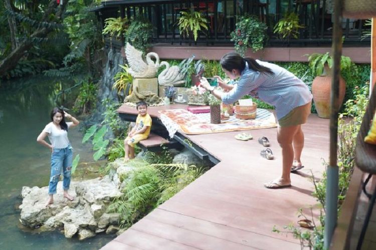 Seorang perempuan tengah bergaya sambil difoto di tempat wisata Krabi, Thailand.