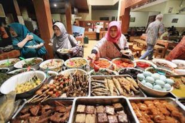 Pengunjung antre untuk memilih menu makan siang di Rumah Makan Sunda Bancakan di Jalan Trunojoyo, Bandung. Makanan khas Sunda banyak digemari para wistawan yang berkunjung ke kota ini.