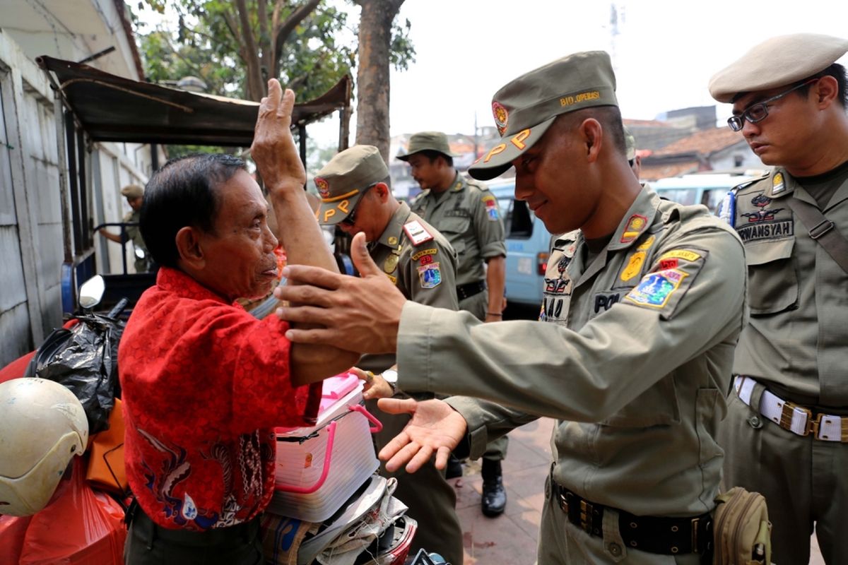 Petugas Satpol PP melakukan penertiban pedagang kaki lima (PKL) yang berjualan di Kawasan Pasar Tanah Abang, Jakarta, Rabu (17/5/2017). Penertiban dilakukan setiap hari menyusul mulai banyaknya PKL yang berjualan di trotoar dan jalan kawasan Pasar Tanah Abang.