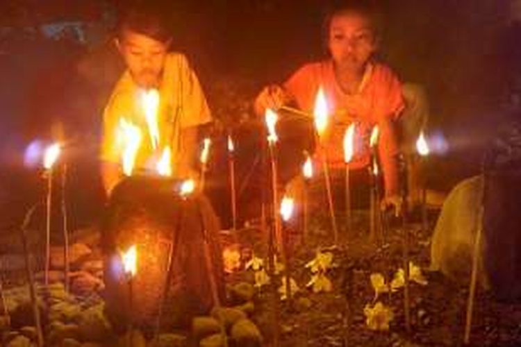 Anak-anak di Dusun Tenges-enges, Gerung, Lombok Barat, saat menyalakan 'dile jojor' di makam. 