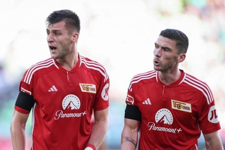 Dua pemain belakang Union Berlin, Robin Knoche (kiri) dan Robin Gosens, berbincang dalam laga melawan Wolfsburg pada lanjutan kompetisi Liga Jerman 2023-2024 di Stadion Volkswagen Arena, Sabtu (16/9/2023). Terkini, Union Berlin akan bertamu ke markas Real Madrid pada matchday pertama Liga Champions 2023-2024. (Foto oleh Ronny Hartmann / AFP)