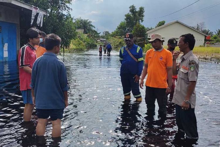 Petugas BPBD Kota Dumai menemui anak-anak agar tidak bermain di lokasi banjir di Kelurahan Bumi Ayu, Kecamatan Dumai Selatan, Kota Dumai, Riau, Senin (1/11/2021) sore.