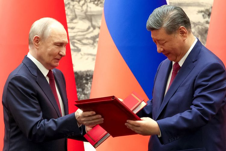 Presiden Rusia Vladimir Putin (kiri) dan Presiden China Xi Jinping (kanan) saat bertukar dokumen dalam penandatanganan berkas di Konferensi Tingkat Tinggi (KTT) di Beijing, China, 20 Mei 2026.