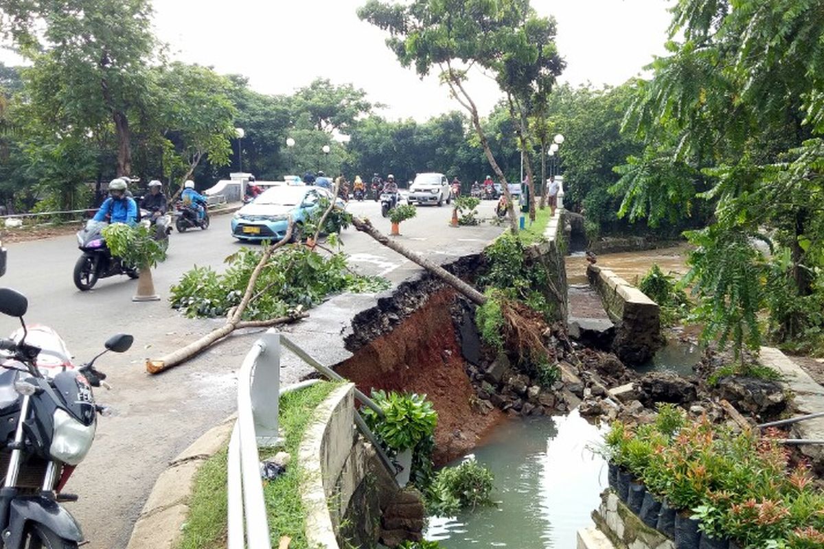 Turap jembatan yang berlokasi di Pondok Kacang Barat, Pondok Aren, Tangerang Selatan, amblas Rabu (1/1/2020) pagi. Hal tersebut dikarenakan debit air yang berada di anak kali Angke melintas deras. 