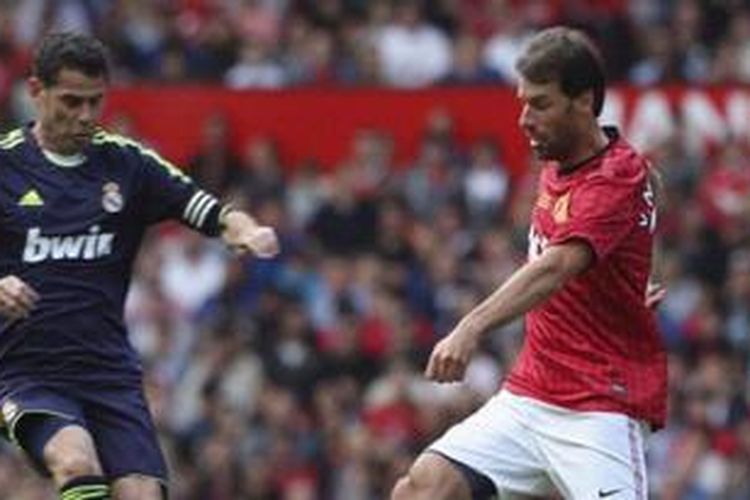 Striker Manchester United Legends, Ruud van Nistelrooy (kanan), mencoba melewati bek Real Madrid Legends, Fernando Hierro (kiri), dalam laga amal di Stadion Old Trafford, Manchester, Minggu (2/6/2013).