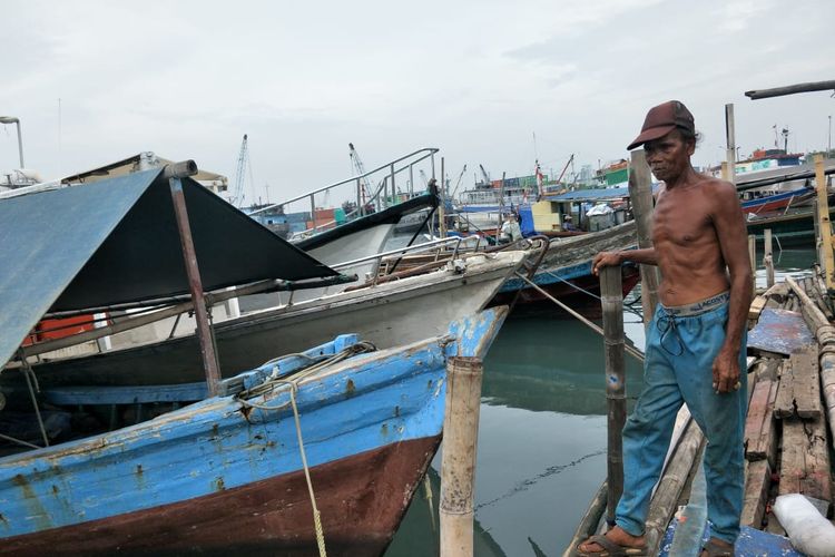 Udin seorang nelayan di Kampung Akuarium, Penjaringan, Jakarta Utara, sedang berdiri di depan perahunya, Kamis (5/11/2020).