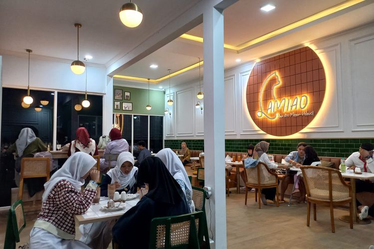 Pengunjung sedang menikmati suasana malam di Lamiao Cat Cafe, Kamis (15/6/2023).