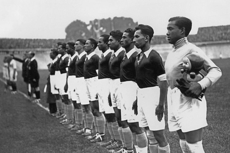 Para pemain tim nasional Hindia Belanda berbaris saat lagu kebangsaan dinyanyikan sebelum dimulainya pertandingan babak penyisihan Piala Dunia melawan Hongaria pada 5 Juni 1938 di Reims, Perancis. Hindia Belanda tersingkir dari turnamen karena kalah 0-6 dari Hongaria.