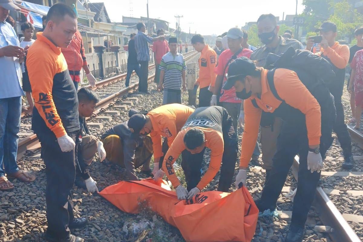 Petugas Command Center 112 Surabaya mengevakuasi korban S yang tertabrak kereta api di perlintasan rel kereta api Jalan Tambak Mayor Utara, Asemrowo, Surabaya, Minggu (8/9/2024).