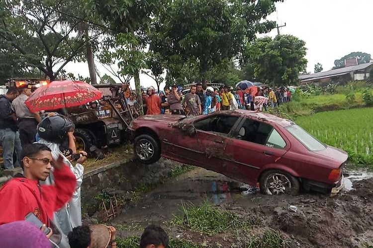 Saat cuaca buruk melanda kembali Kota Tasikmalaya, mobil sedan BMW alami kecelakaan tunggal terjun ke sawah akibat pecah ban dan jalanan licin di Jalan Sewaka Kota Tasikmalaya, Kamis (30/1/2020).