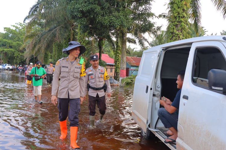 Kapolres Rohil AKBP Andrian Pramudianto (depan) bersama anggotanya saat meninjau banjir di Kecamatan Rantau Kopar, Kabupaten Rokan Hilir, Riau, Selasa (2/1/2024).