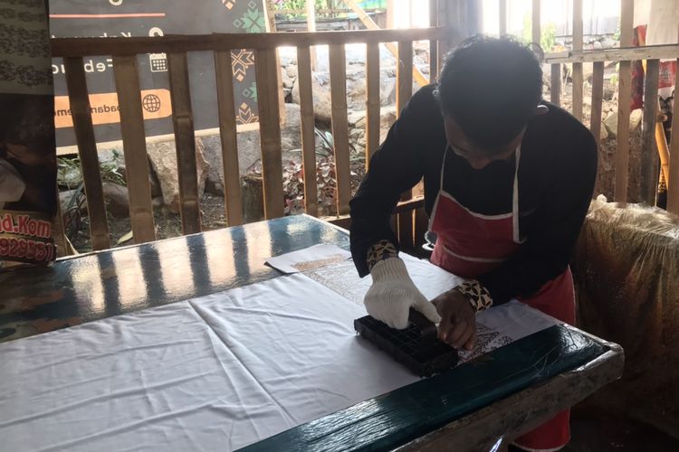 Pemilik usaha batik khas Minang bermerek Salingka Tabek, Yusrizal (29) saat ditemui di rumahnya di Sawah Parik, Desa Bawah Duku, Kecamatan Kotobaru, Solok, Sumatera Barat pada Rabu (18/5/2022). Ia sedang mempraktekkan proses pembuatan batik cap.