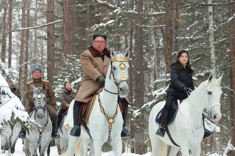 Foto tak bertanggal yang dirilis media Korea Utara KCNA pada 4 Desember 2019 memperlihatkan Kim Jong Un (tengah) menunggangi kuda putih berlapis emas ketika berkunjung ke Gunung Keramat Paektu.
