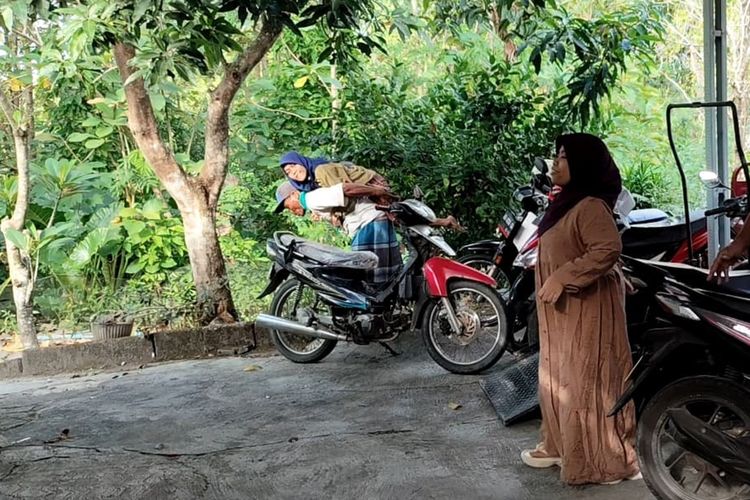 Penyandang disabilitas daksa asal Kemusu, Boyolali, Nur Janah (25), digendong oleh ayahnya saat hendak mengikuti pelatihan menjahit di Sanggra Kresna Patra di Desa Klewor yang didirikan oleh Sri Setyaningsih (43), Jumat (27/6/2025) pagi. Sri Setyaningsih sendiri juga merupakan disabilitas daksa. Sejak 2021, ia telah memfasilitasi sekitar 500 penyandang disabilitas lain untuk mengikuti pelatihan di Kresna Patra.