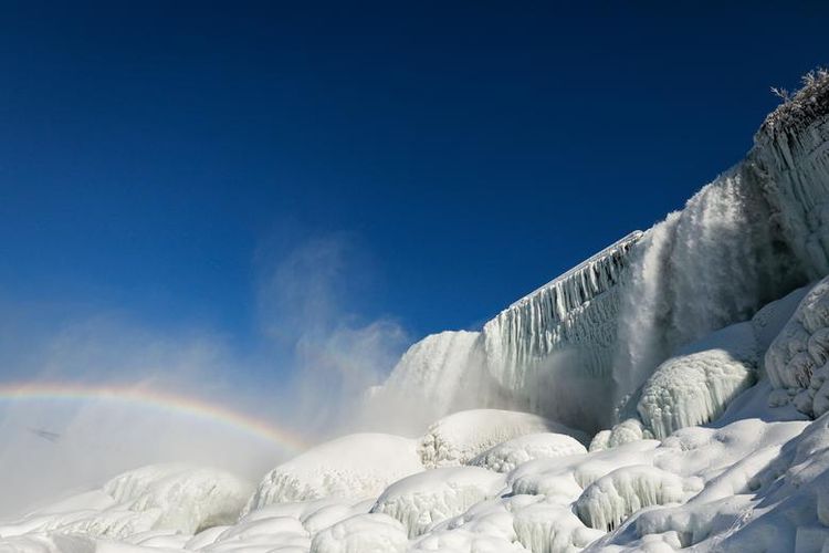 Pemandangan air yang mengalir di antara es yang membeku di Air Terjun Niagara yang terlihat dari bawah air terjun, New York, Amerika Serikat (dok. REUTERS/Lindsay DeDario).