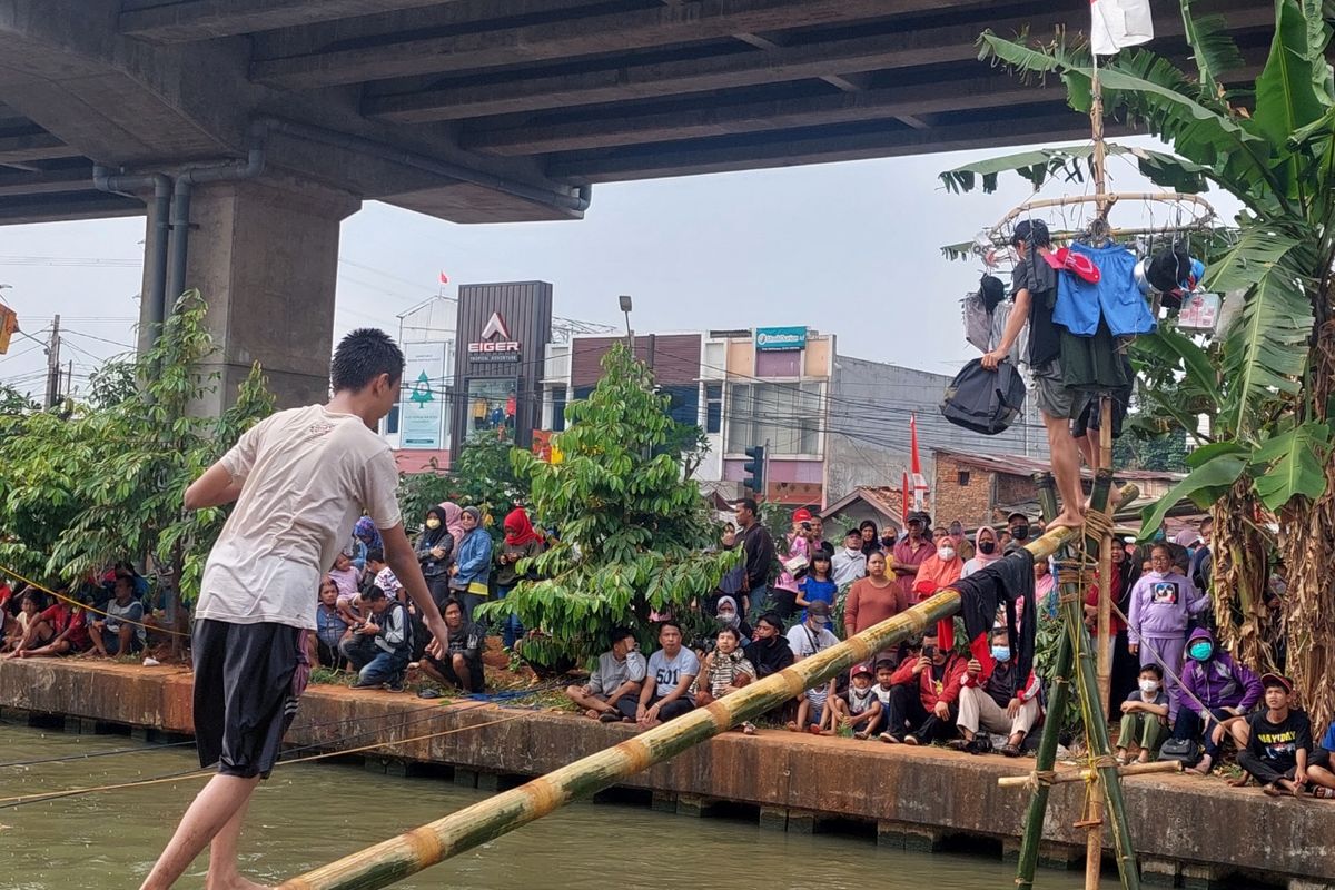 Suasana lomba panjat pinang yang berlangsung di aliran Kali Malang, RW04, Kelurahan Cipinang Melayu, Kecamatan Makasar, Jakarta Timur, Minggu (28/8/2022).