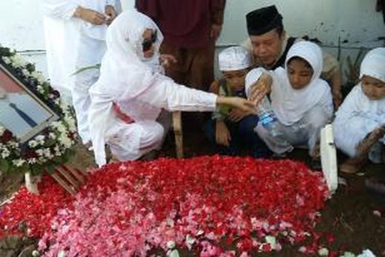 Istri dan anak Kopilot Aviastar Yudhistira Febby Ariyanto  sedang menabur bunga. 