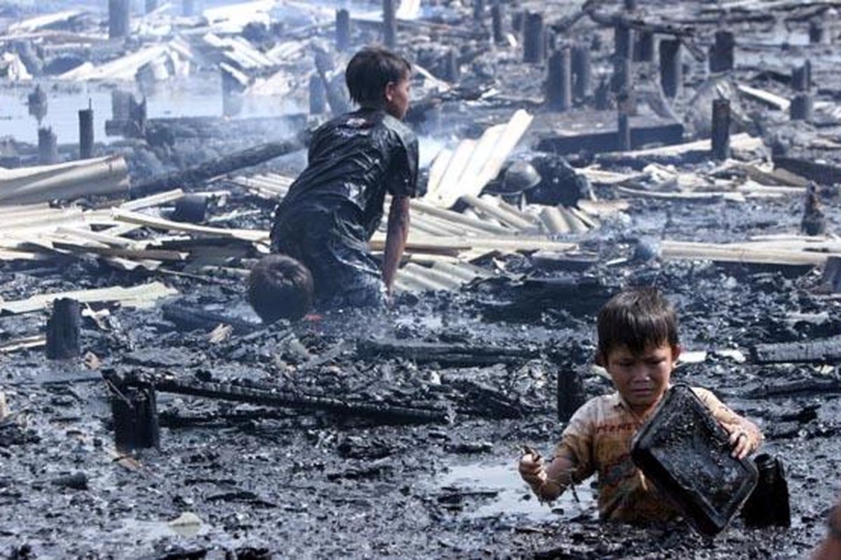 Demi besi bekas, pemulung cilik ikut menceburkan diri ke dalam sisa kebakaran ratusan gubuk semipermanen yang dibangun di atas rawa di samping Tempat Pelelangan Ikan  Muara Angke, Jakarta Utara, Senin (4/4). Jumlah gubuk yang terbakar diperkirakan mencapai 200 unit. Saat ini warga korban kebakaran mengungsi di sekitar lokasi kebakaran. 