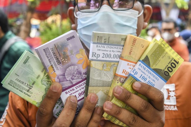 Ilustrasi warga menunjukan uang baru usai ditukarkan di mobil kas keliling Bank Indonesia (BI). Simak lokasi penukaran uang baru di kas keliling dan titik perbankan di wilayah Cirebon selama bulan Ramadhan 2024
