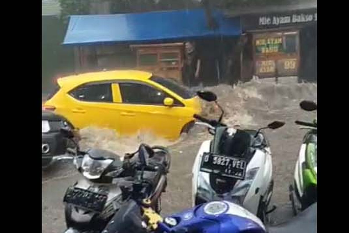 Sebuah mobil tampak terseret banjir yang menerjang Kota Bandung, Kamis (24/12/2020).