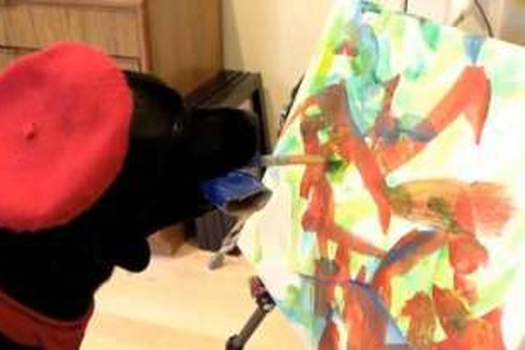 Seekor anjing labrador retriever hitam dari Long Island, Amerika Serikat melakukan aksi unik, melukis untuk acara penggalangan dana.