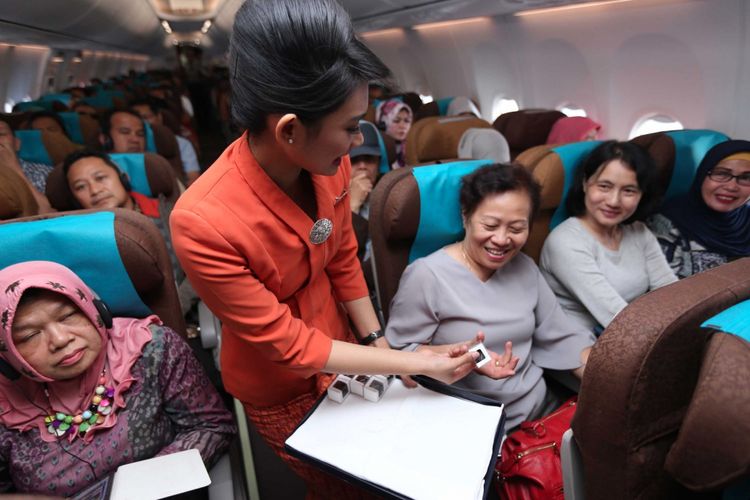 Pramugari Garuda Indonesia membagikan cokelat di tengah Kartini Flight rute Jakarta-Padang, Jumat (21/4/2017).